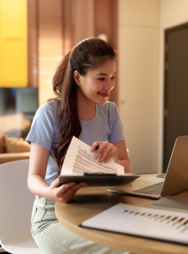 Smiling woman working with files and laptop, showing organised and efficient data entry support for business owners.