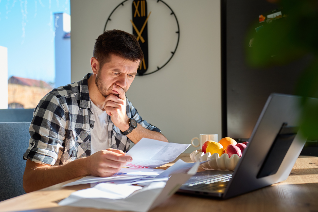 Small business owner reviewing paperwork and invoices while catching up on bookkeeping records