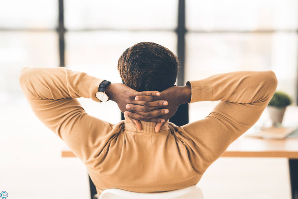 Small business owner relaxing at desk after organising bookkeeping and business finances